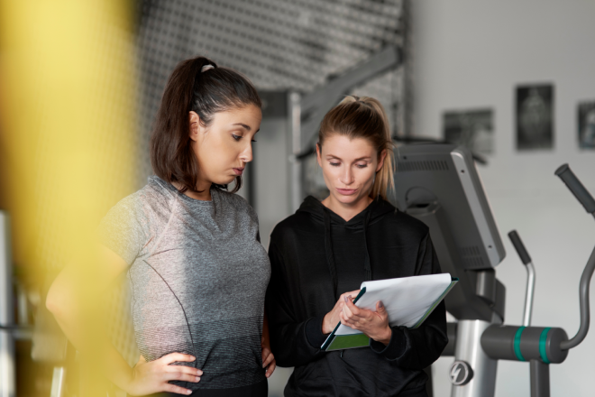 two-women-looking-at-a-fitness-contract